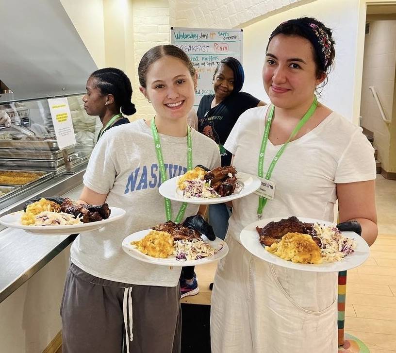 Josephine and a fellow intern serving lunch at the shelter, June 2024