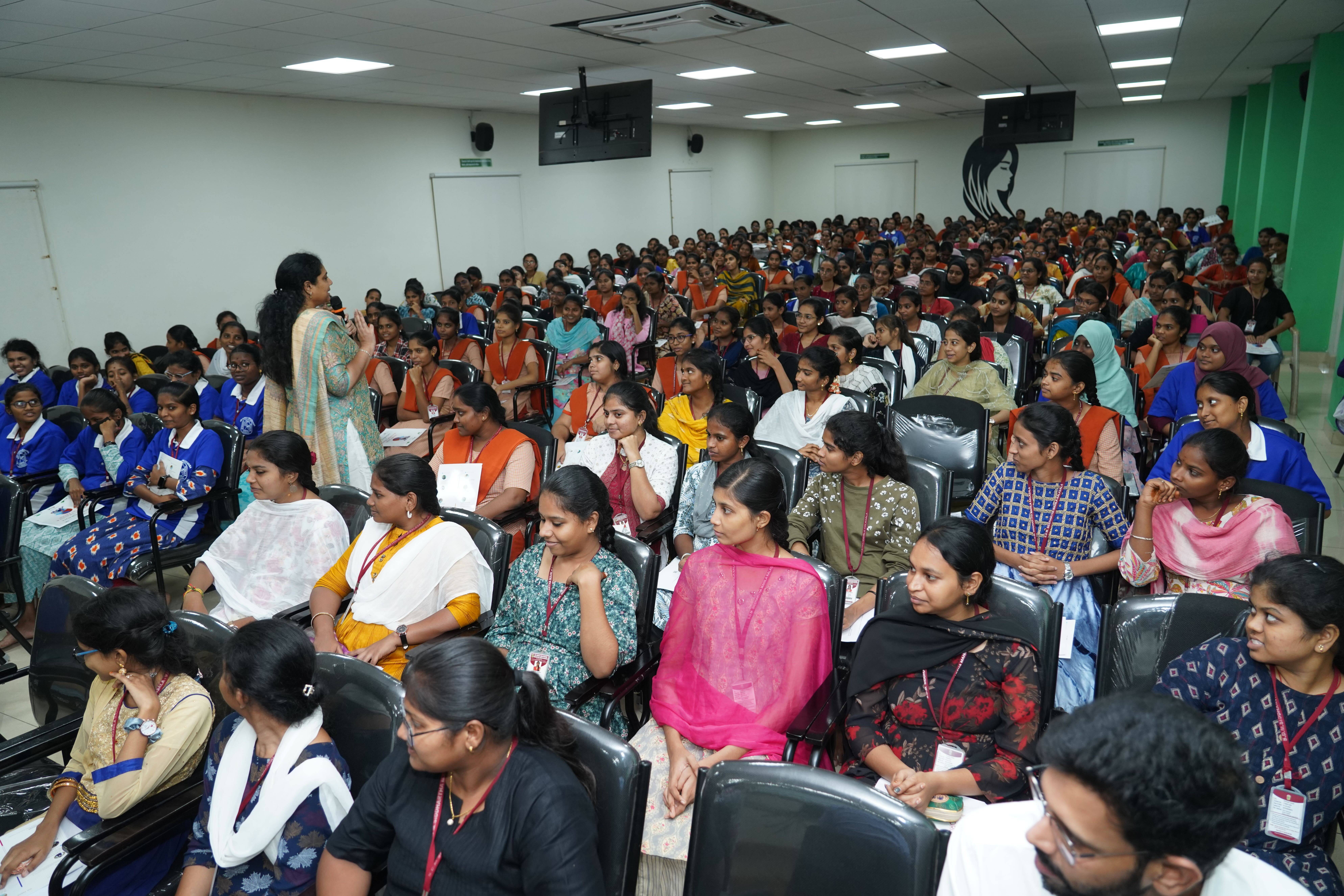 Psychologist Dr. Meena Medikonda walking through the crowd speaking into a microphone