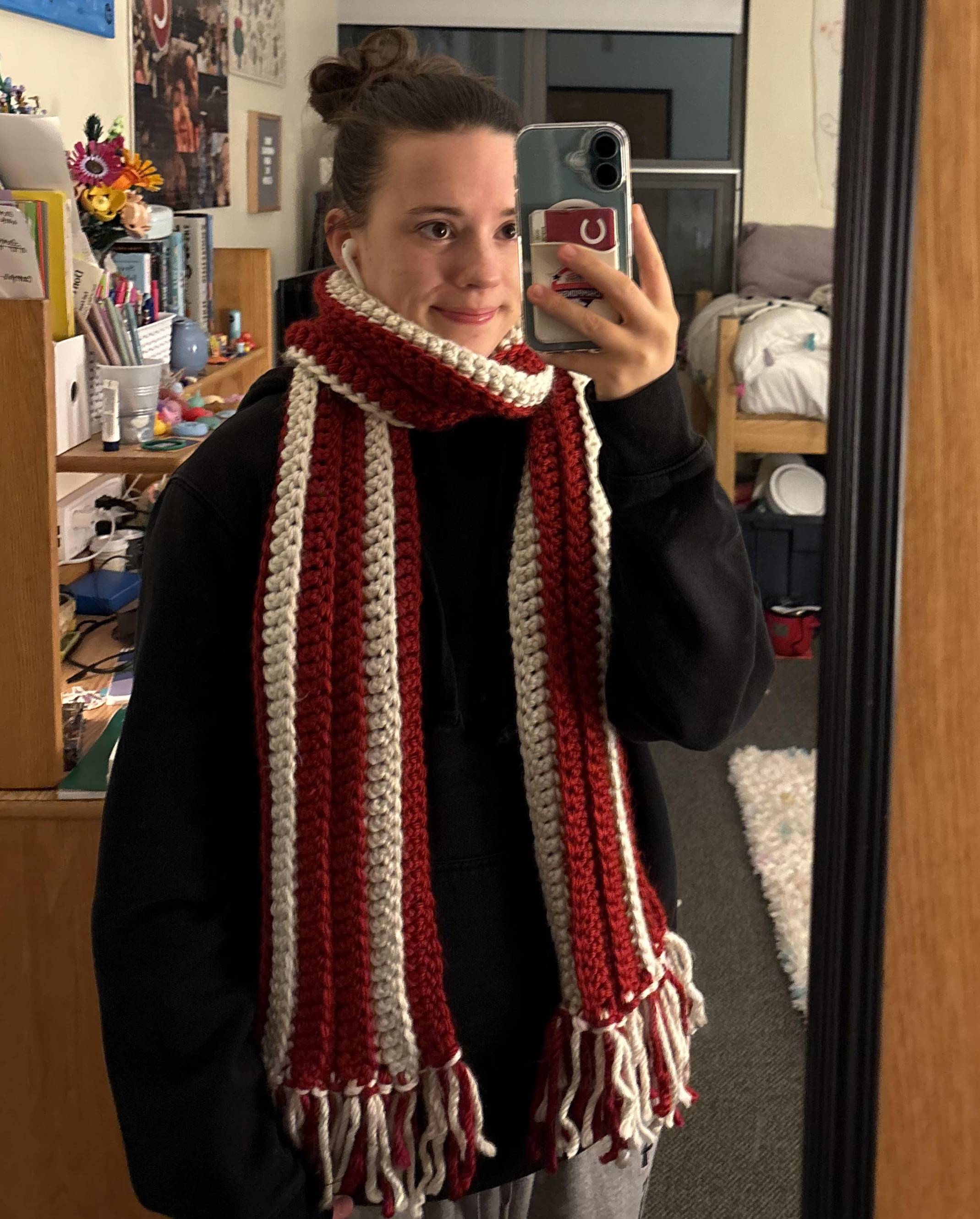 Julianna preparing to go outside during the winter with a scarf she made herself