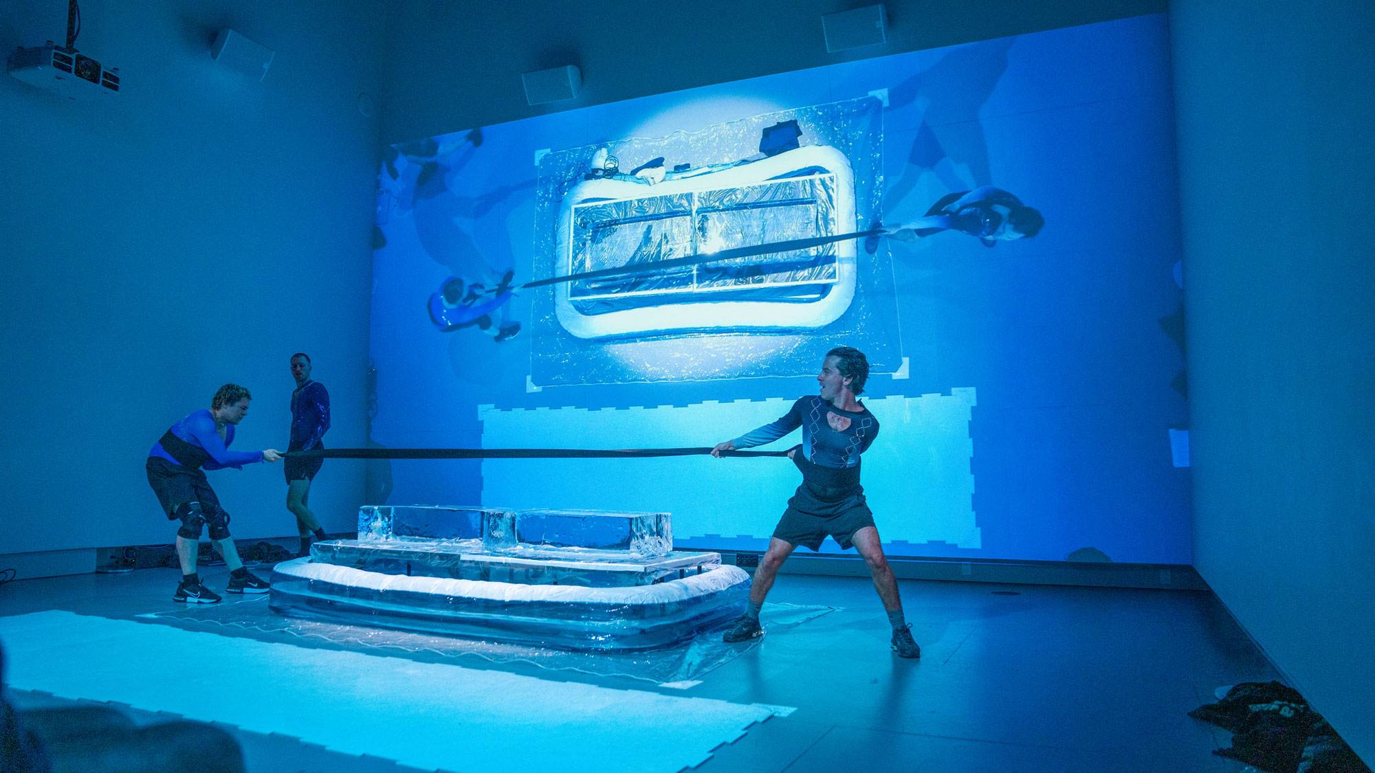 Two performers play tug-of-war over blocks of ice