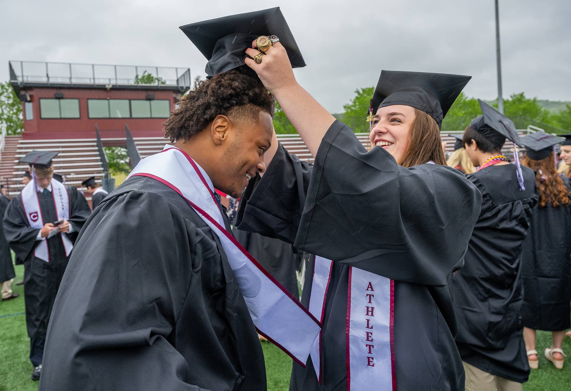 Brendan Cassamajor ’25, receives some help putting on his cap from Lilly Saleeby ’25