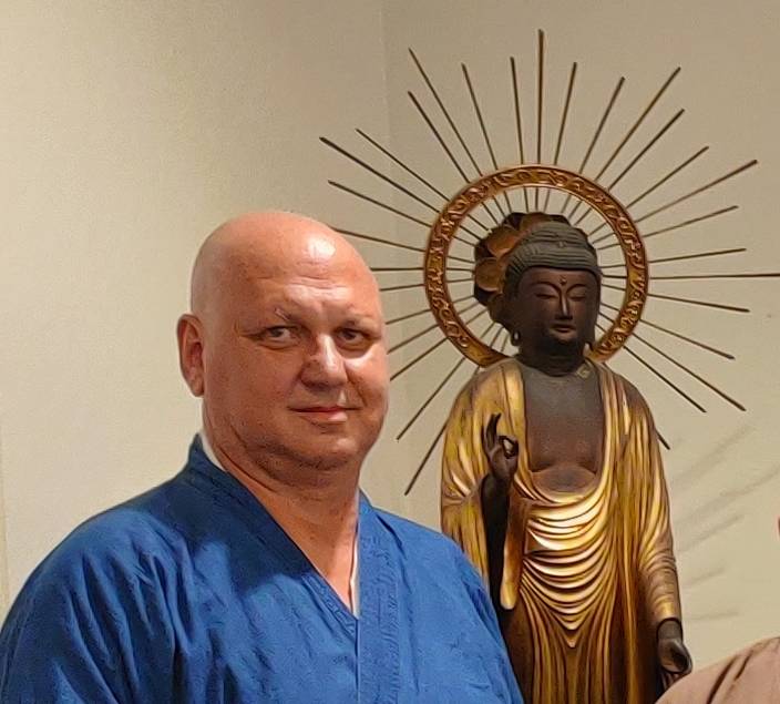 Zen monk Kūshu beside a Buddha statue