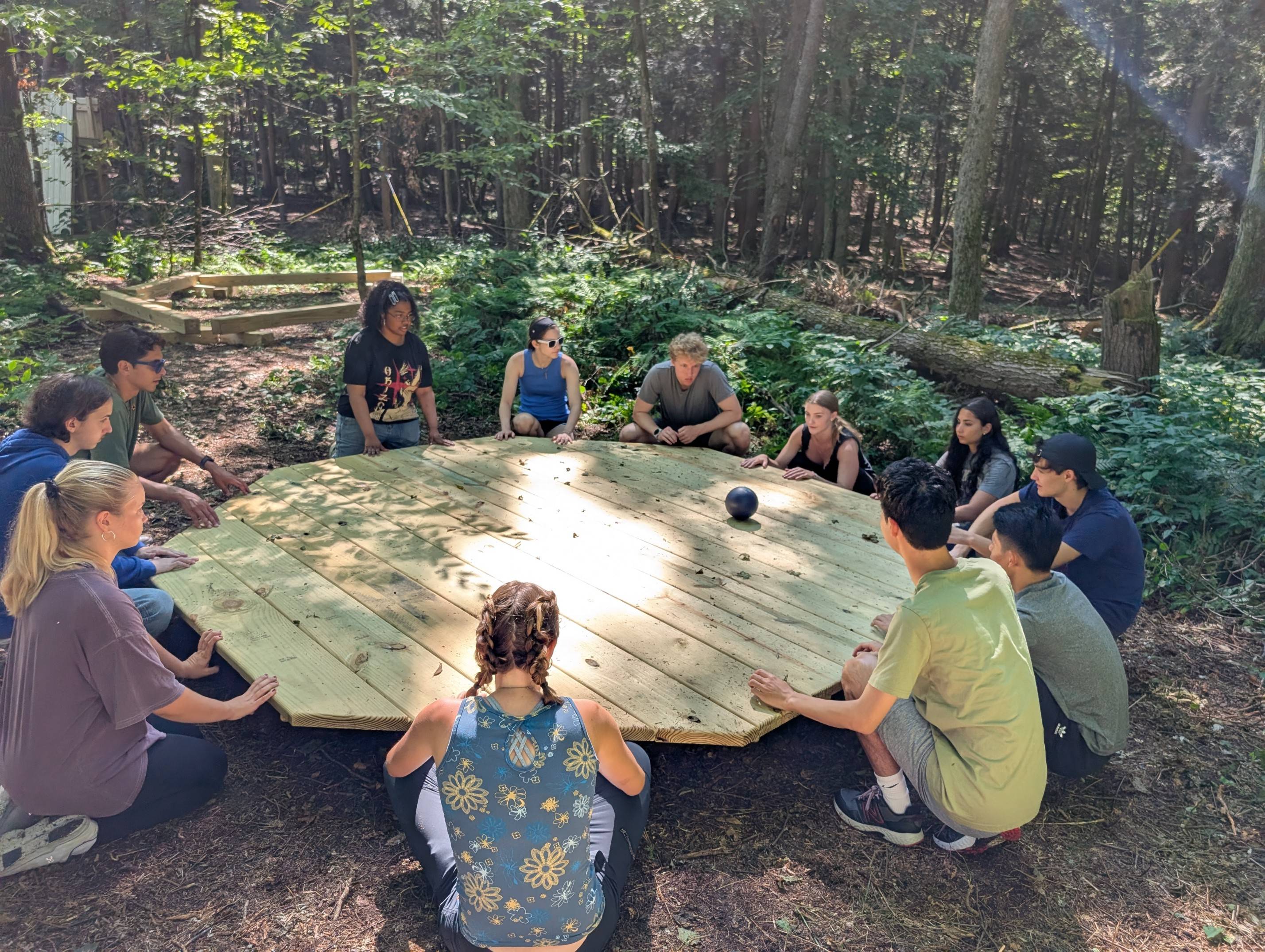 AMS Scholars gather outside in wooded area to play game