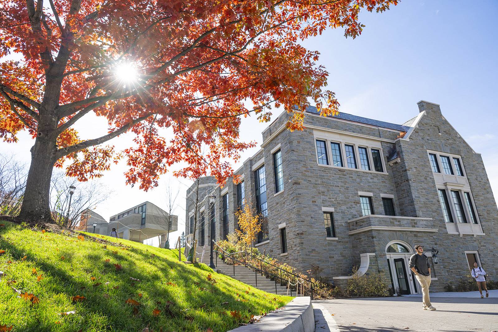 A student walks out of Bernstein Hall on a sunny day