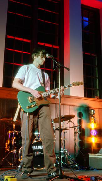 A student plays guitar on stage