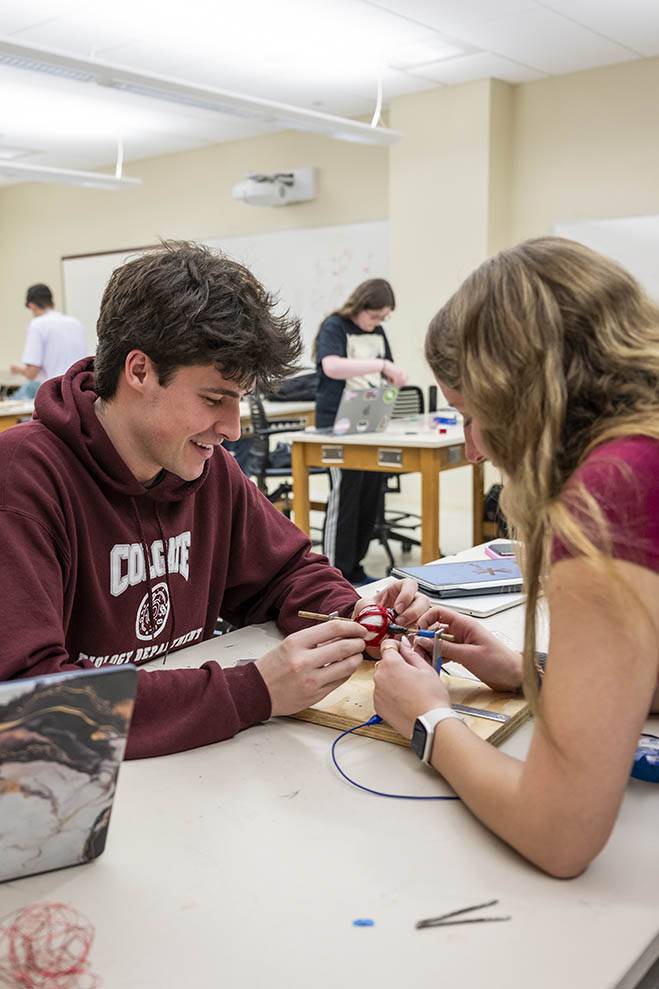 Two students work on a physics project
