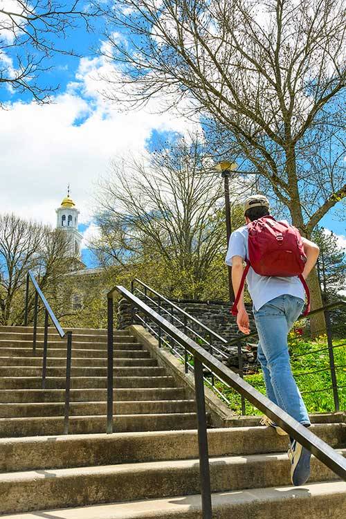 A student walks up stairs towards Memorial Chapel