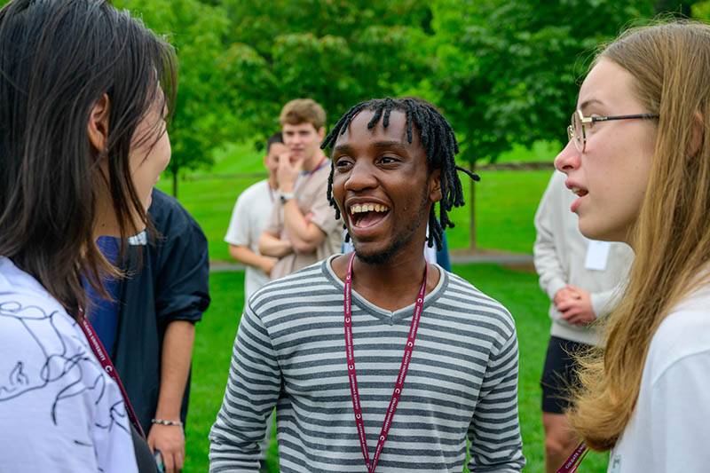 Three international students talk and laugh