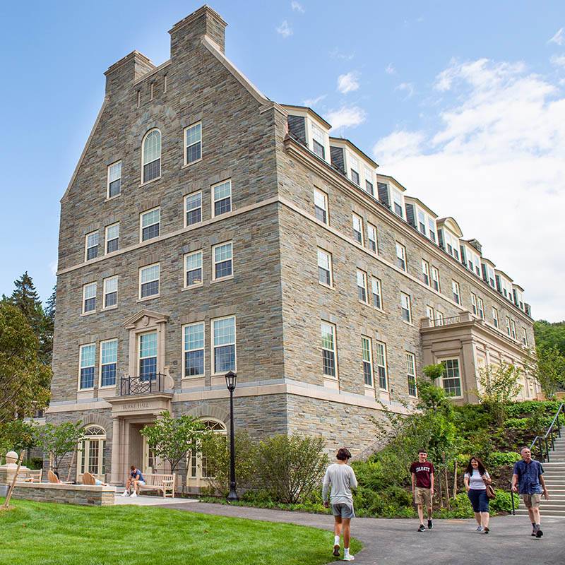 Students and their parents walk past a residence hall