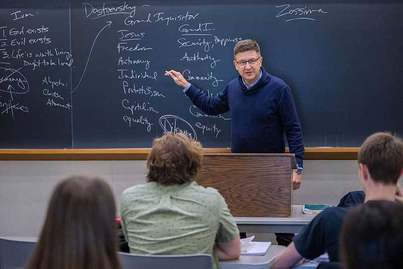 David Dudrick stands in front of a chalk board