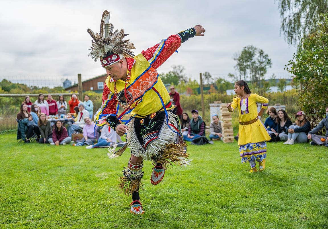 Students watch as an indigenous dance is performe