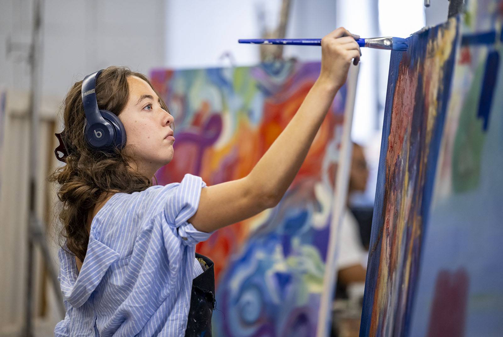 A student paints in the studio