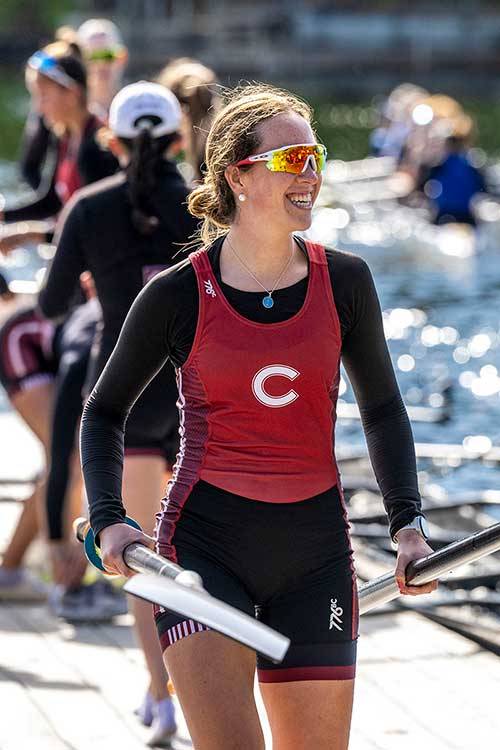A women's rowing team walk along the dock