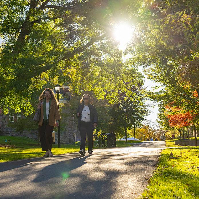 Two staff members walk on a path