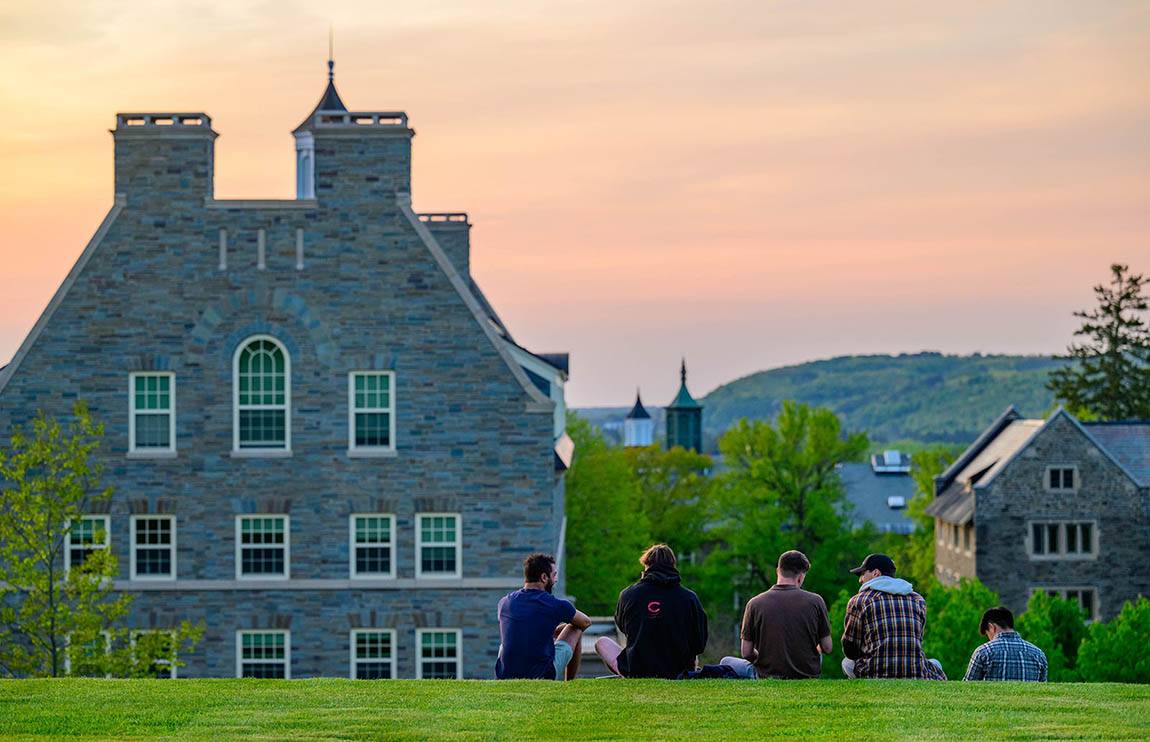 Seniors sit on a hill watching the sunset