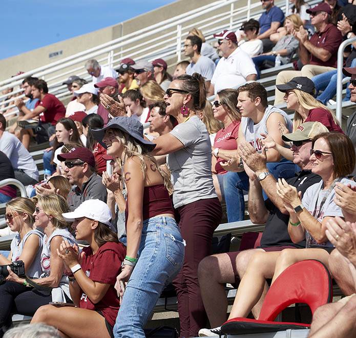 A crowd cheers on the football players