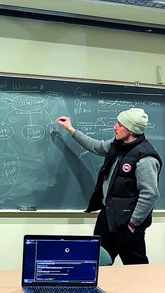 Sebastian Tamburro writing on a chalkboard