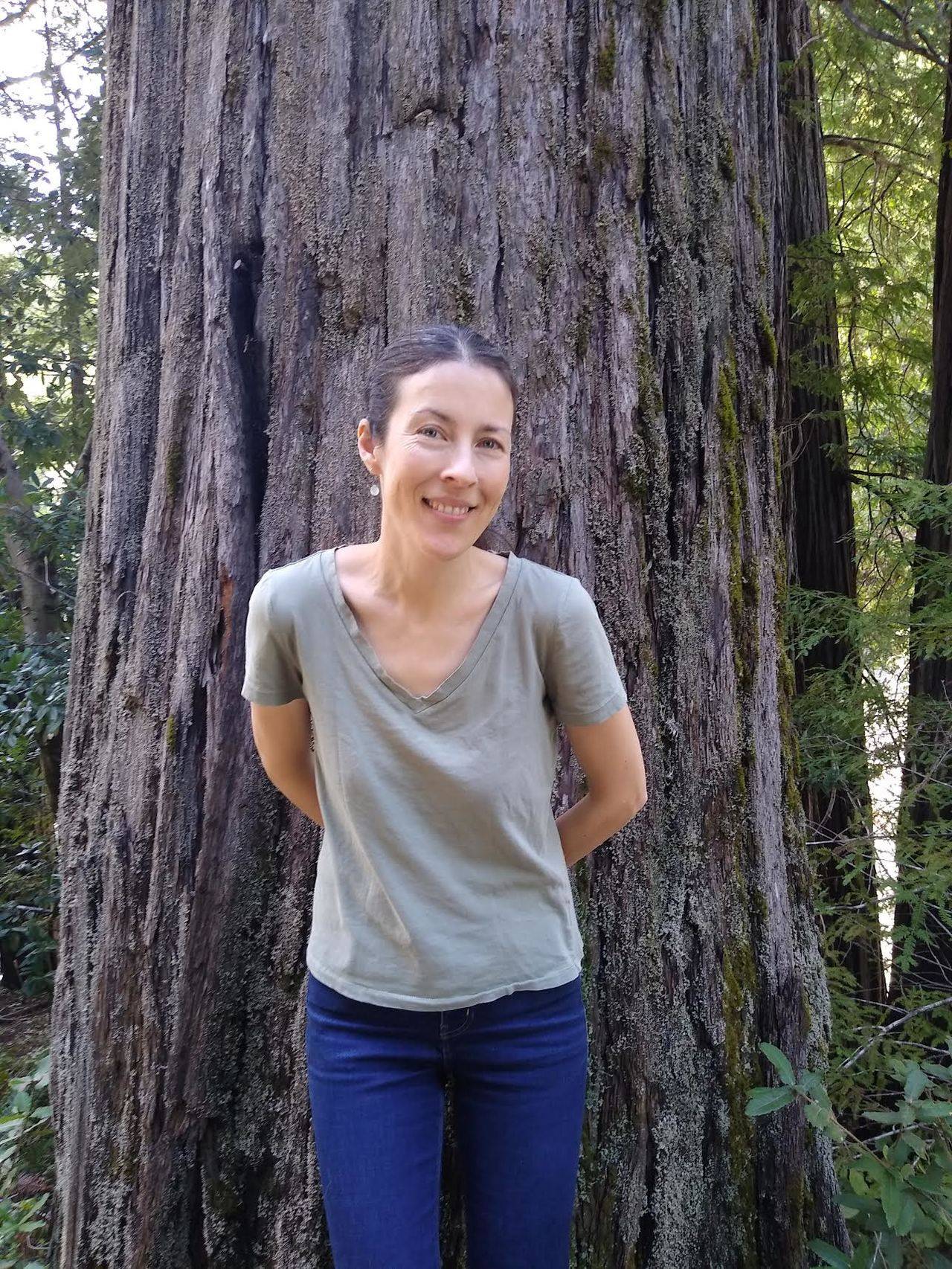 Photo of Professor Heather Roller leaning up against a tree.