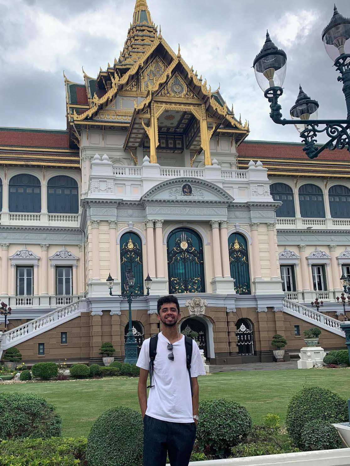 Photo of Vishnu in a white shirt standing in front of an ornate building.