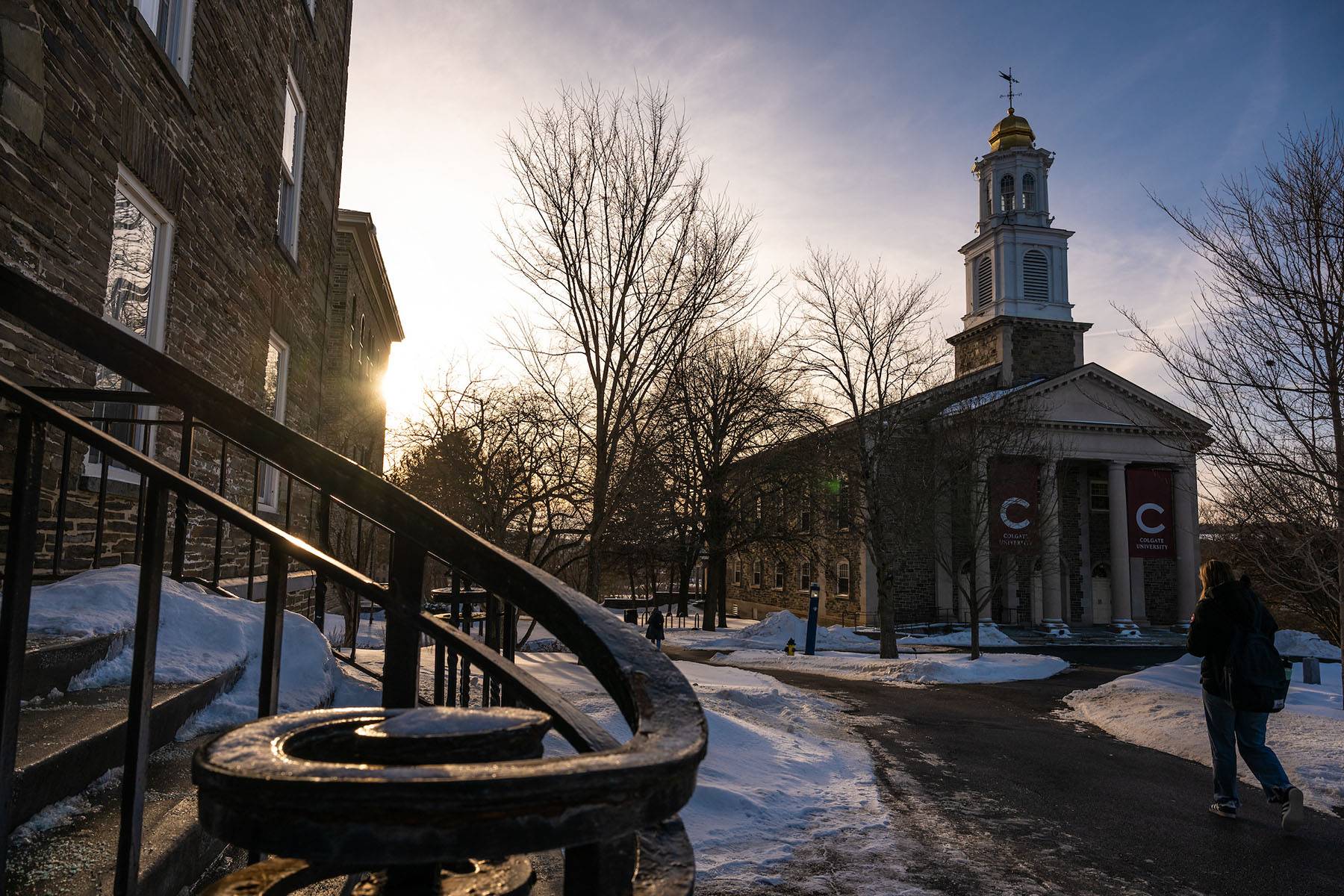 A snowy academic quad, with students walking by the Memorial Chapel