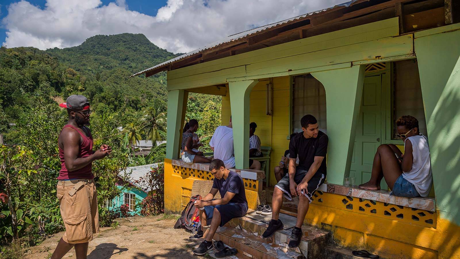 Students site outside a village home on a class excursion in Jamaica