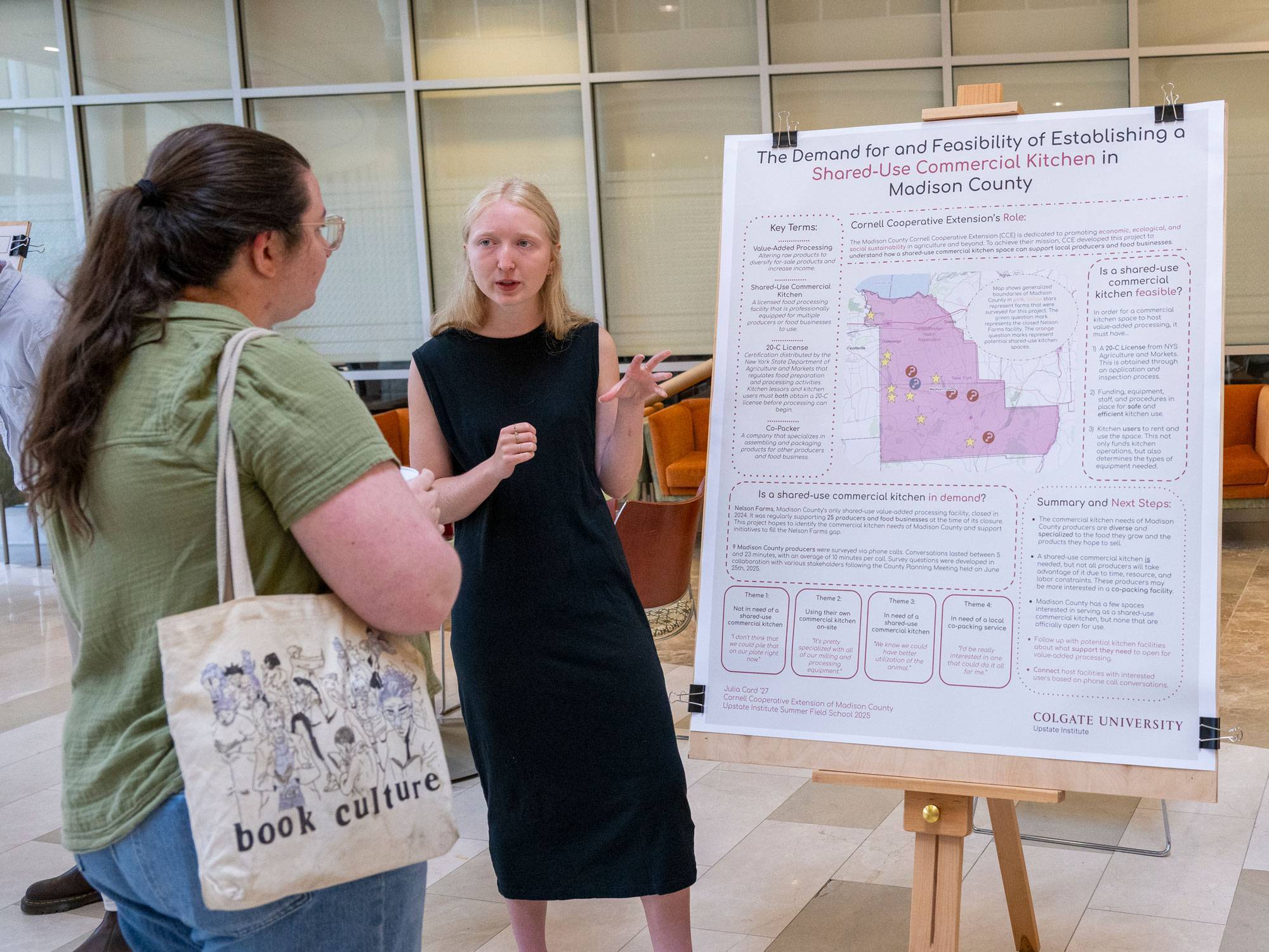 Julia Card ’27 stands next to research poster