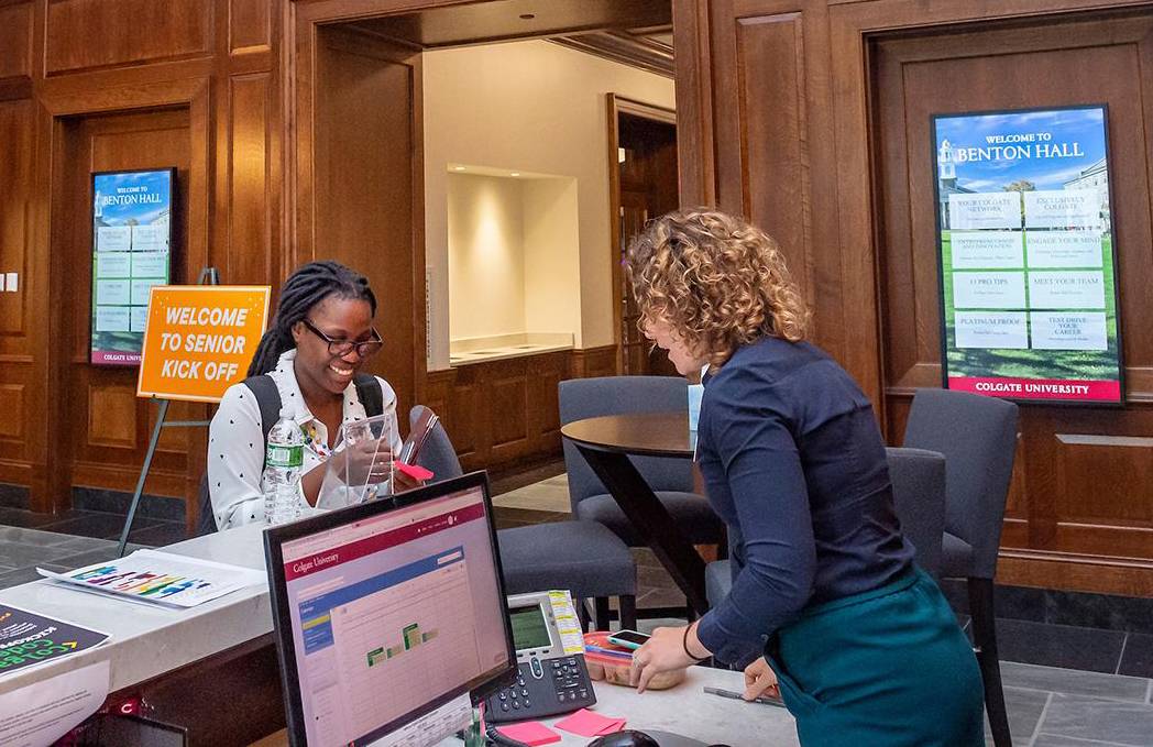 Jessie Darrow helps a student at the front desk of Benton Hall