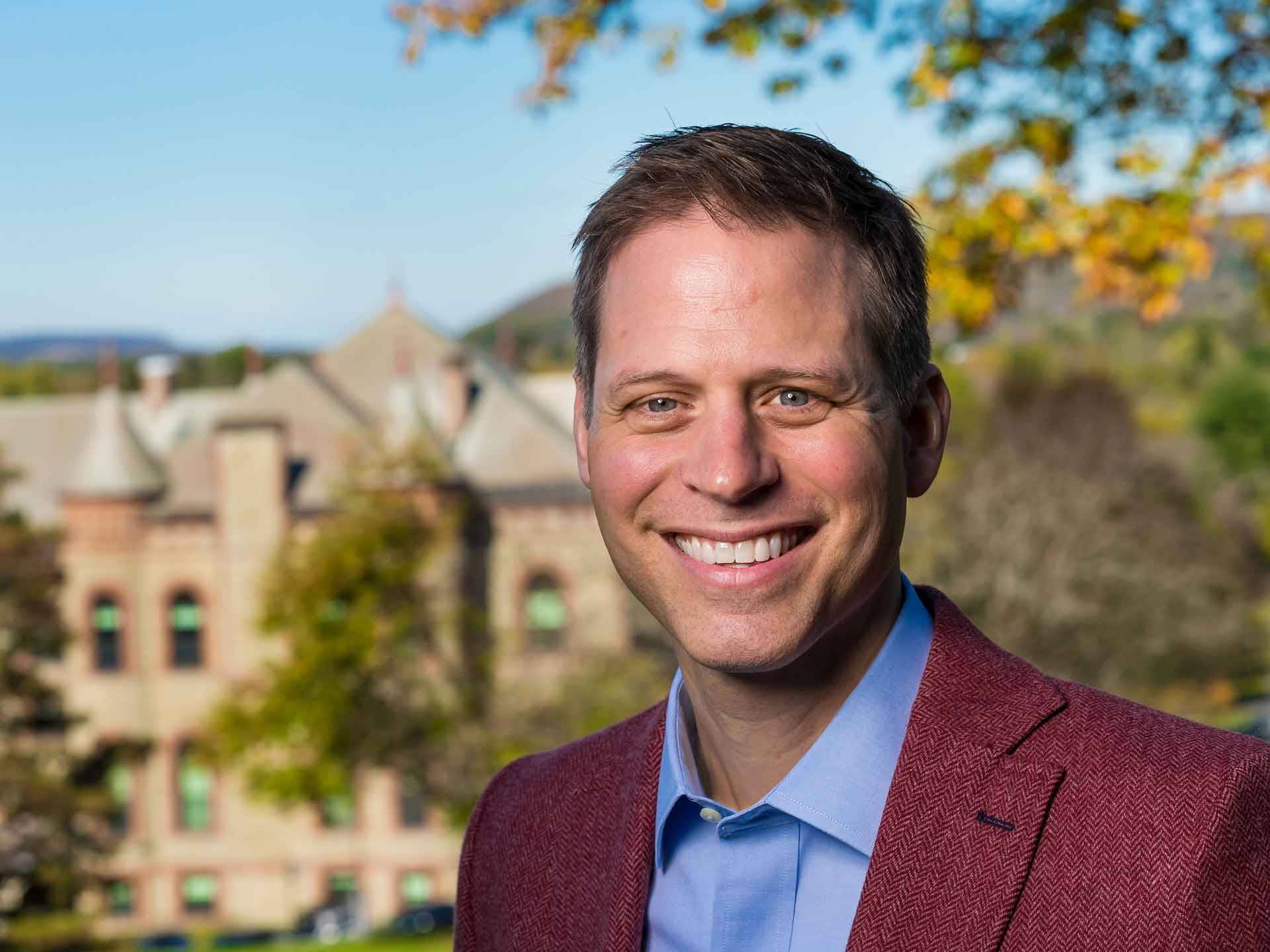 Portrait of VP and Dean of the College Paul J. McLoughlin II, JB Colgate Hall in the backdrop