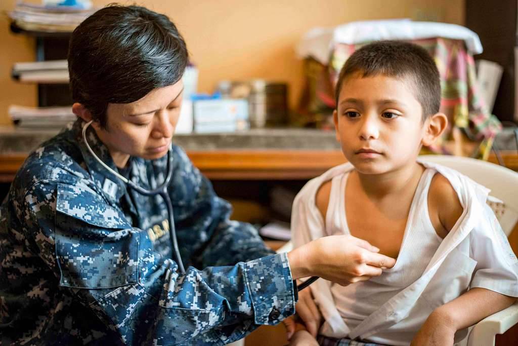 Medical officer listens to a child's heartbeat
