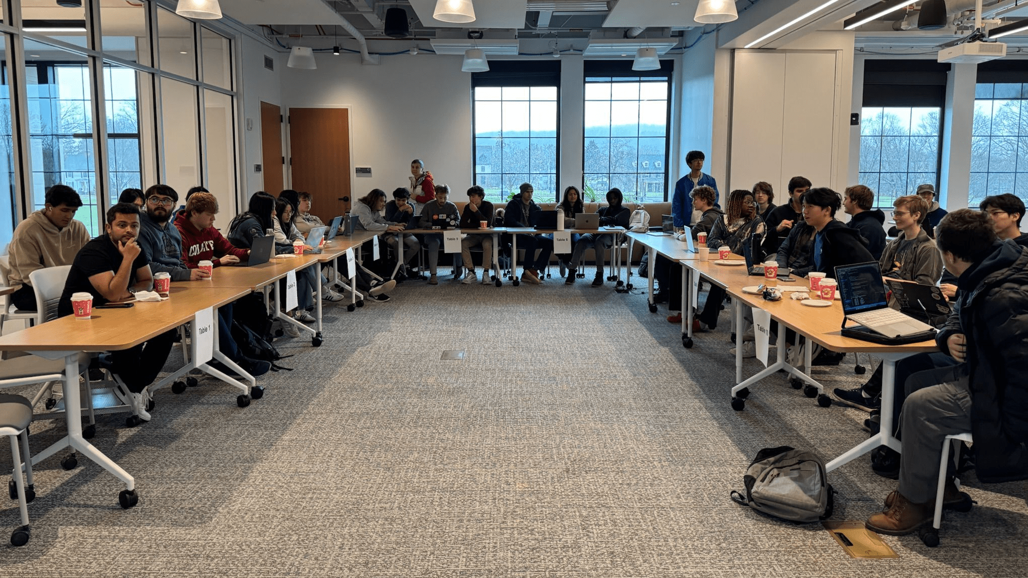 Participants collaborating on projects at their tables during the Gate Hacks event.