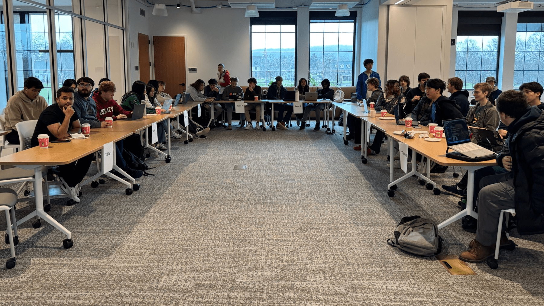 Participants collaborating on projects at their tables during the Gate Hacks event.