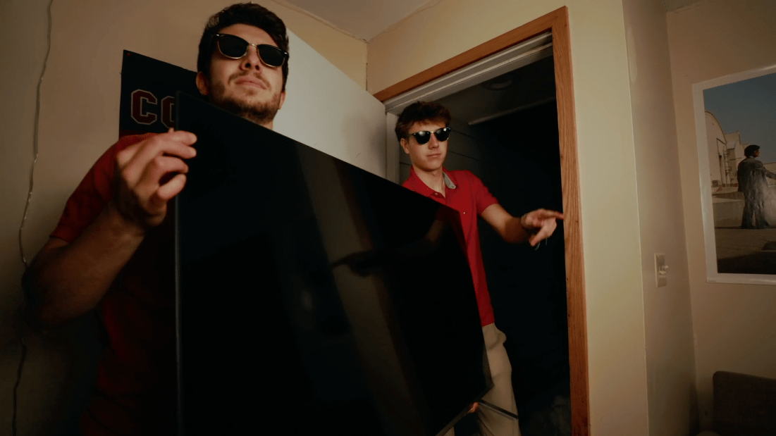 Two students carry television