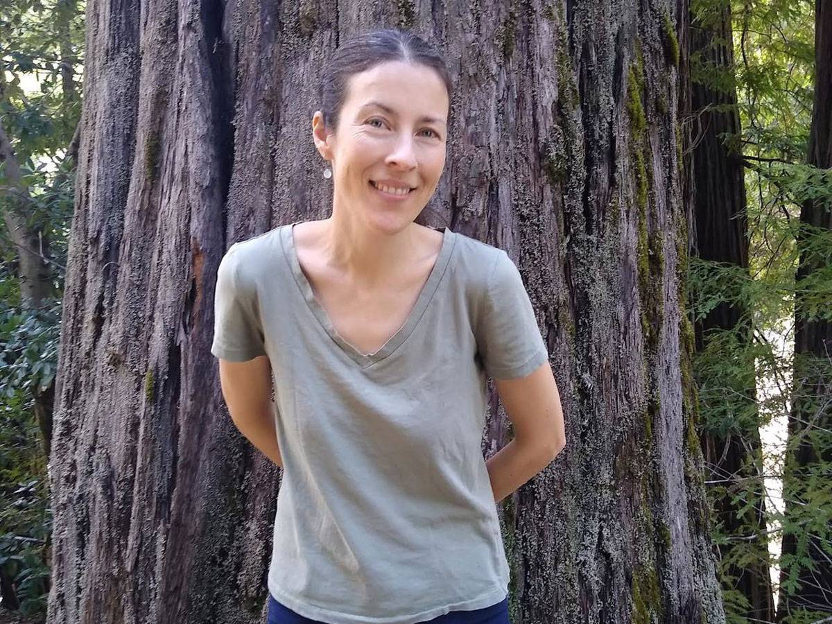 Photo of Professor Heather Roller leaning up against a tree.