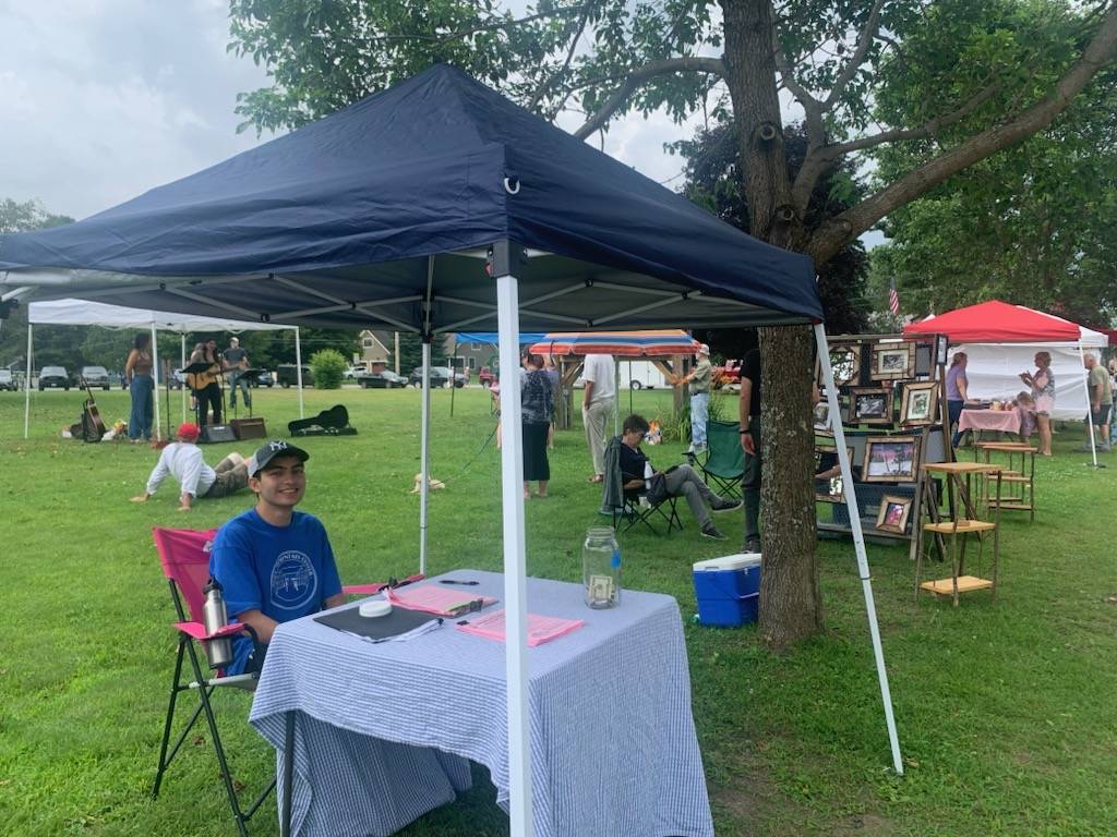 Max Shah sitting at a table at a farmers market