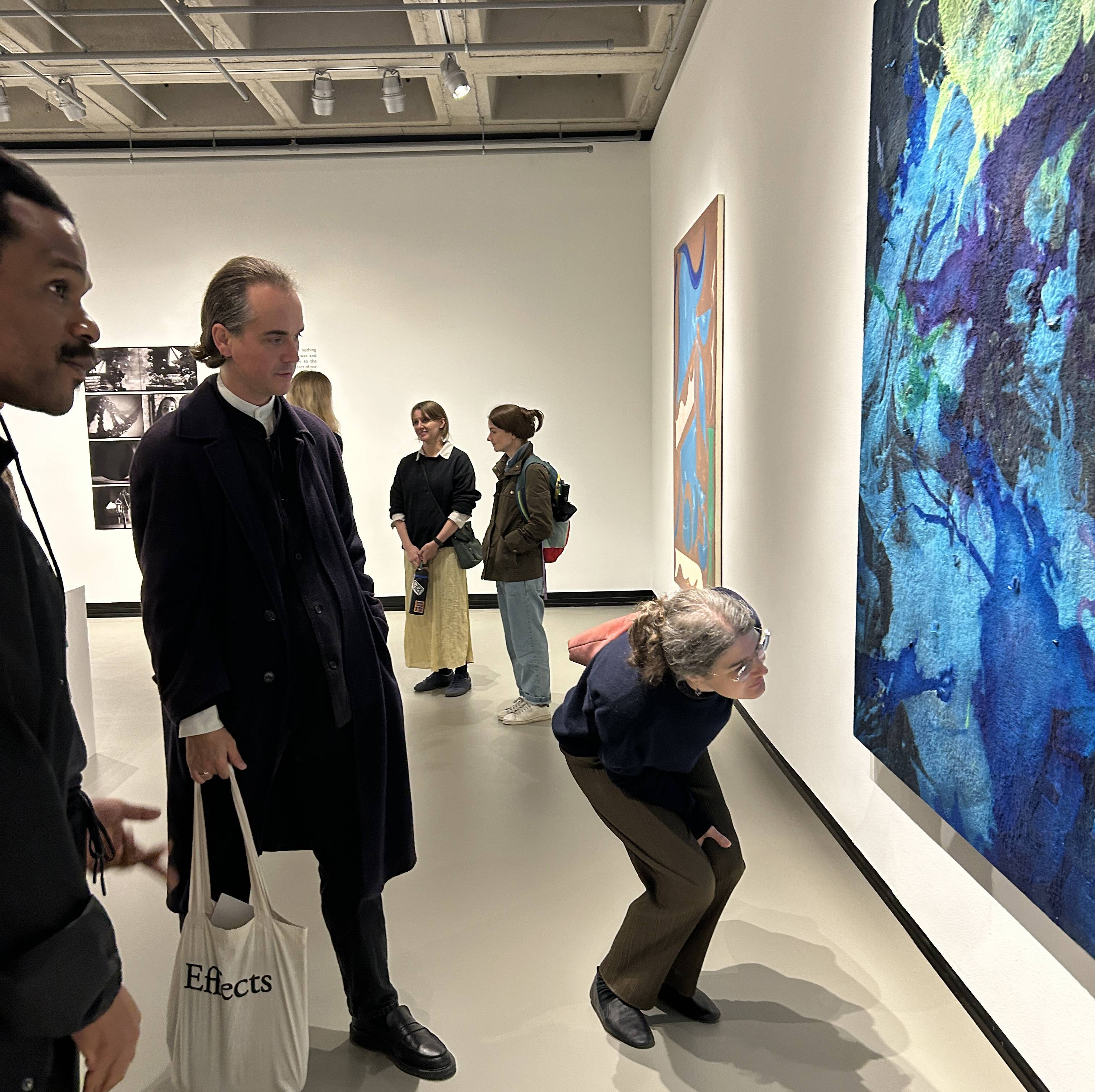 Exhibiting artists (left to right) Noel Anderson, Christopher Page, and Lakshmi Luthra discuss Anderson's piece, "Alcindor Lost in the Sirens' Song" on view in the HOLES exhibition.