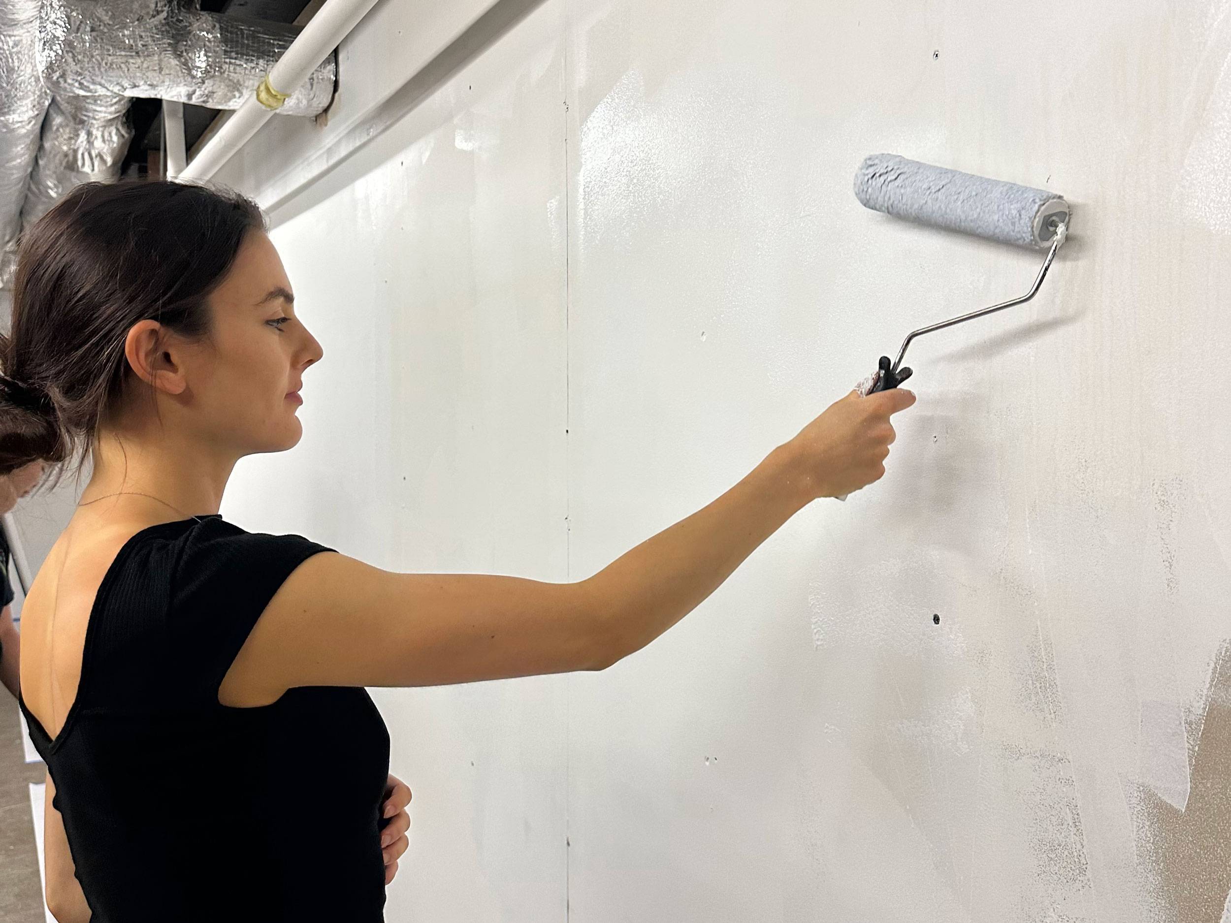 LJ paints a wall at the Center