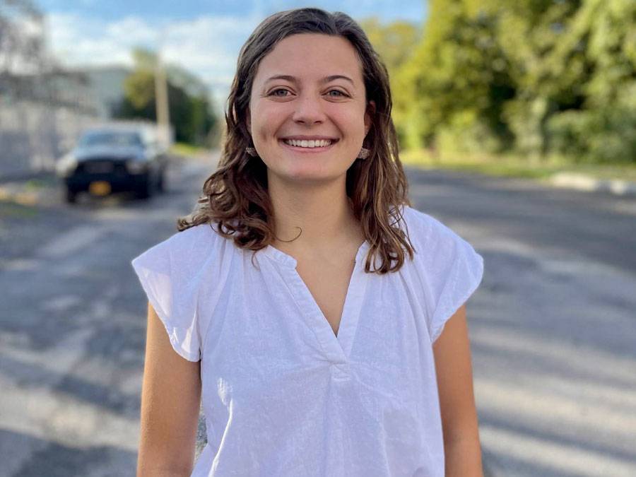 Photo of Kelsey Bennett '22 in a white shirt with a blue sky in the background.