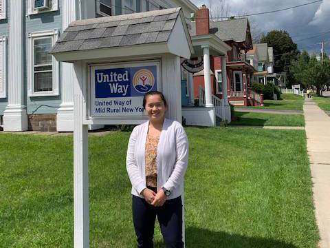 Katie Keyes stands in front of the sign at the United Way office in Norwich