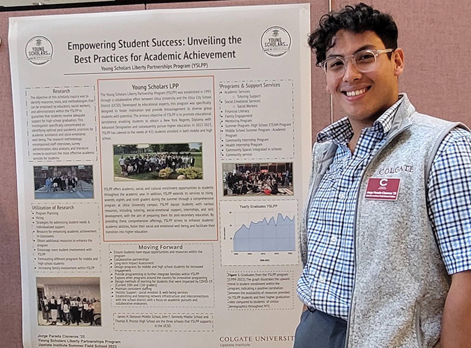 Jorge stands in front of his research poster about the Young Scholars program