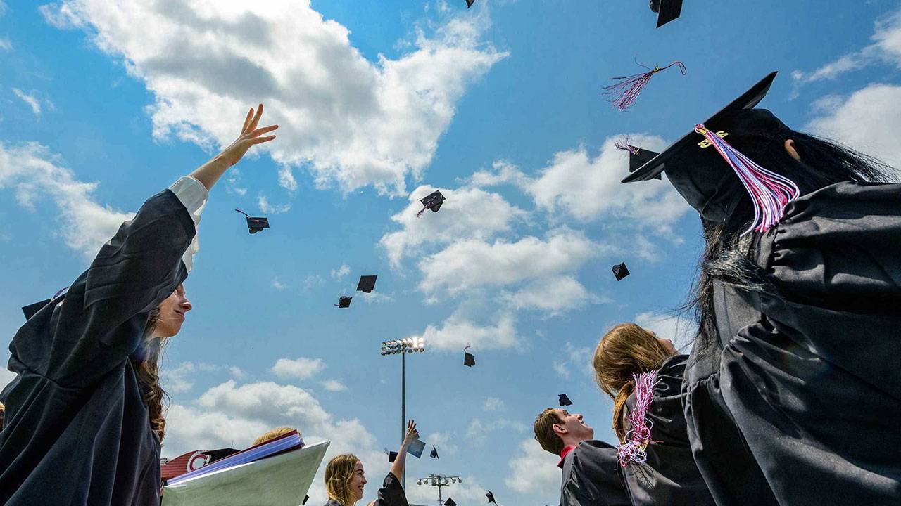 Students throw their caps in the air at graduation