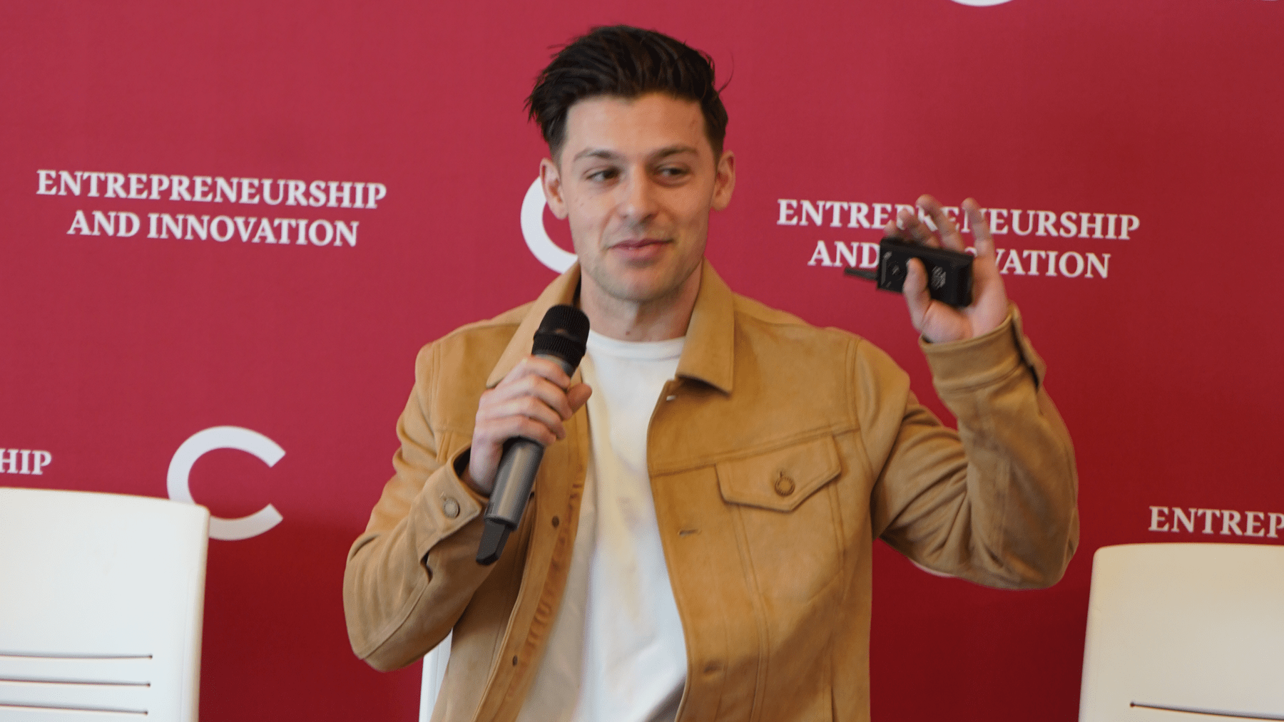Nick Freud holding a microphone while speaking at a TIA Incubator session.