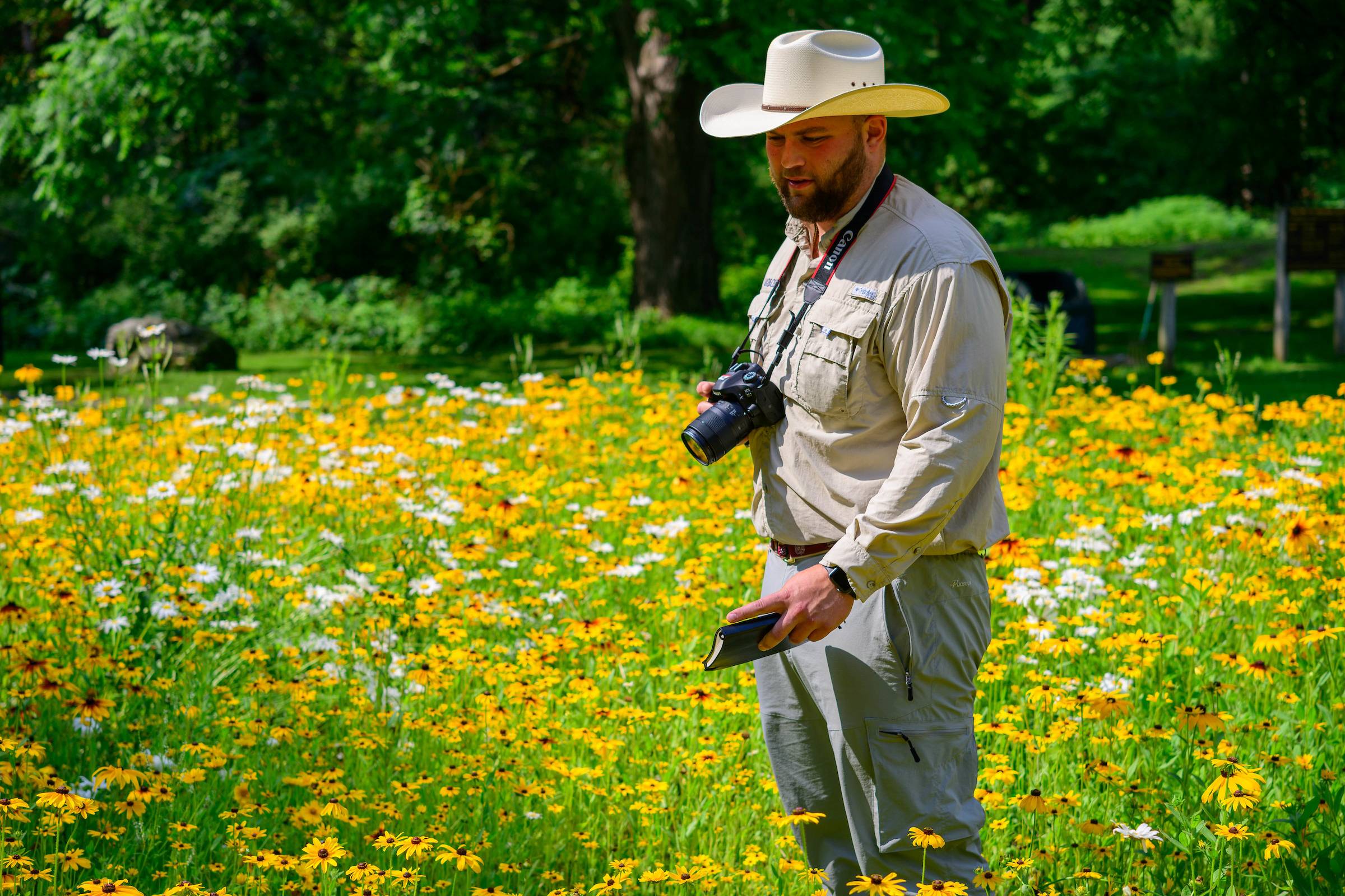 Matthew McGeary '24 out standing in a field of wildflowers.  Image credit to Mark DiOrio.