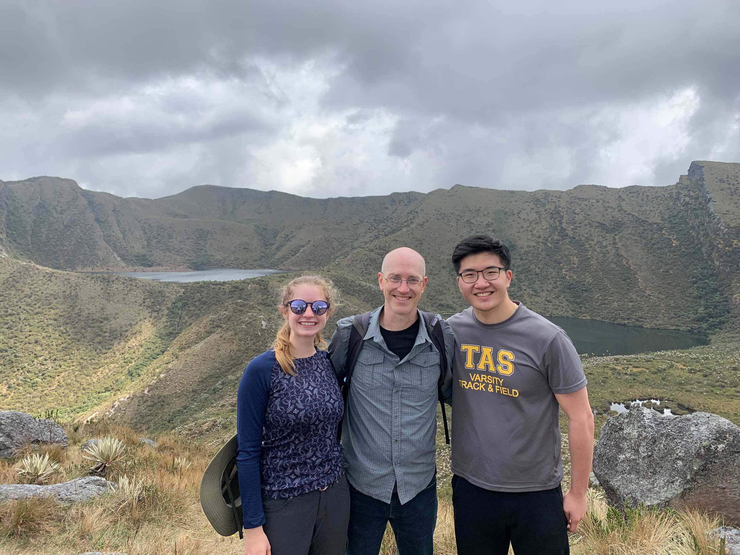 students and professor stand in front of mountain in Colombia