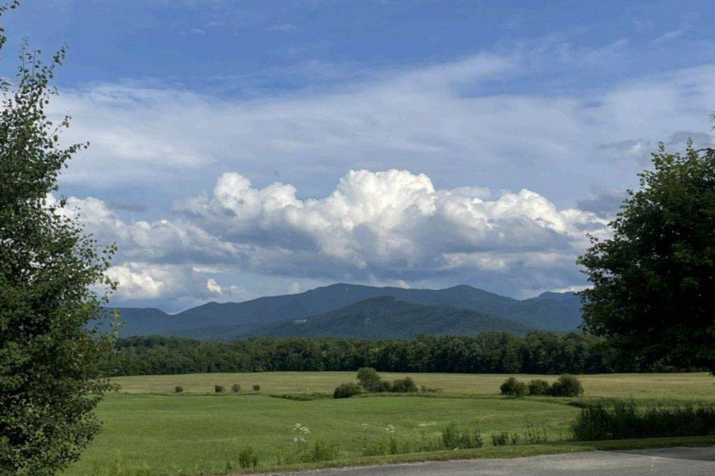 Scenic photo of the Adirondack Mountains with blue sky and clouds.