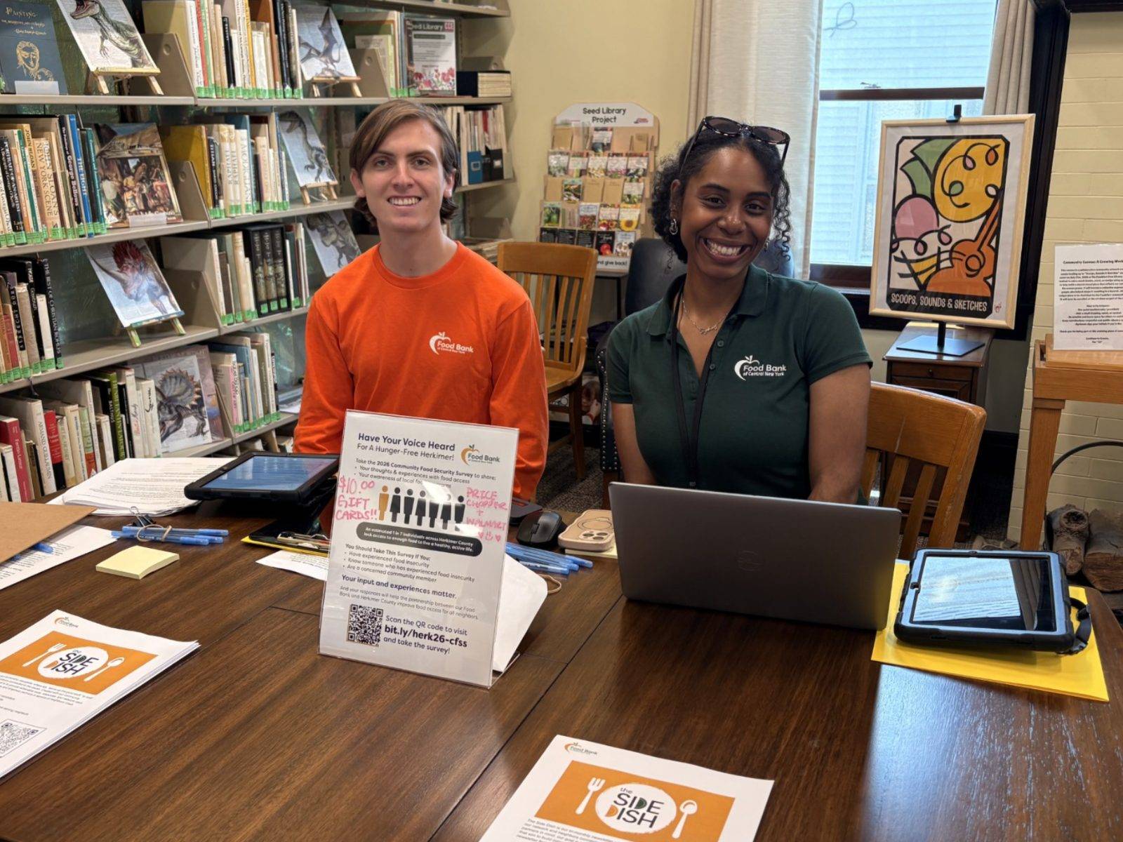 Allan Crounse ‘27 (left) tables at the Frankfort Free Library for the Herkimer County Community Food Security Survey with Sydney Quilty-Koval (right), the Community and Neighbor Engagement Coordinator at FBCNY.