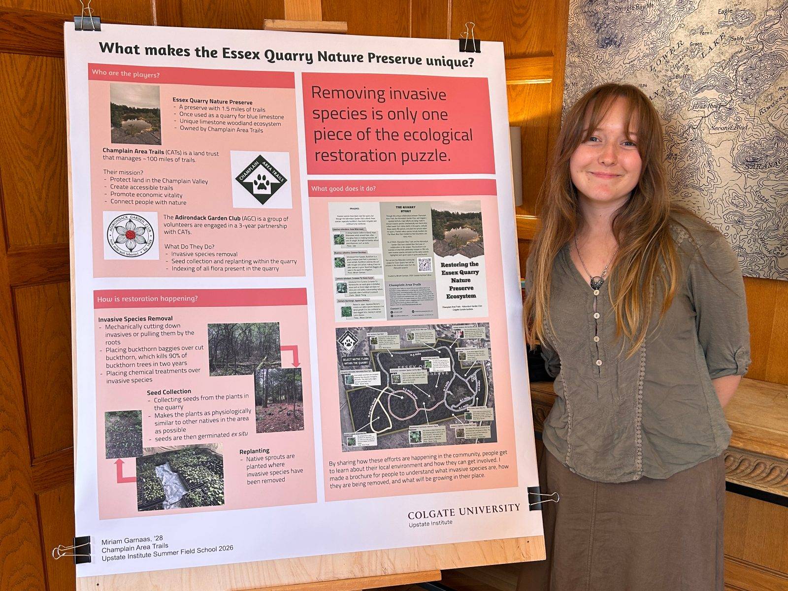 Miriam Garnaas ’28 stands with her research poster showing her work with Champlain Area Trails (CATs), a non-profit organization in the Adirondacks this summer as part of the Upstate Institute Summer Field School.