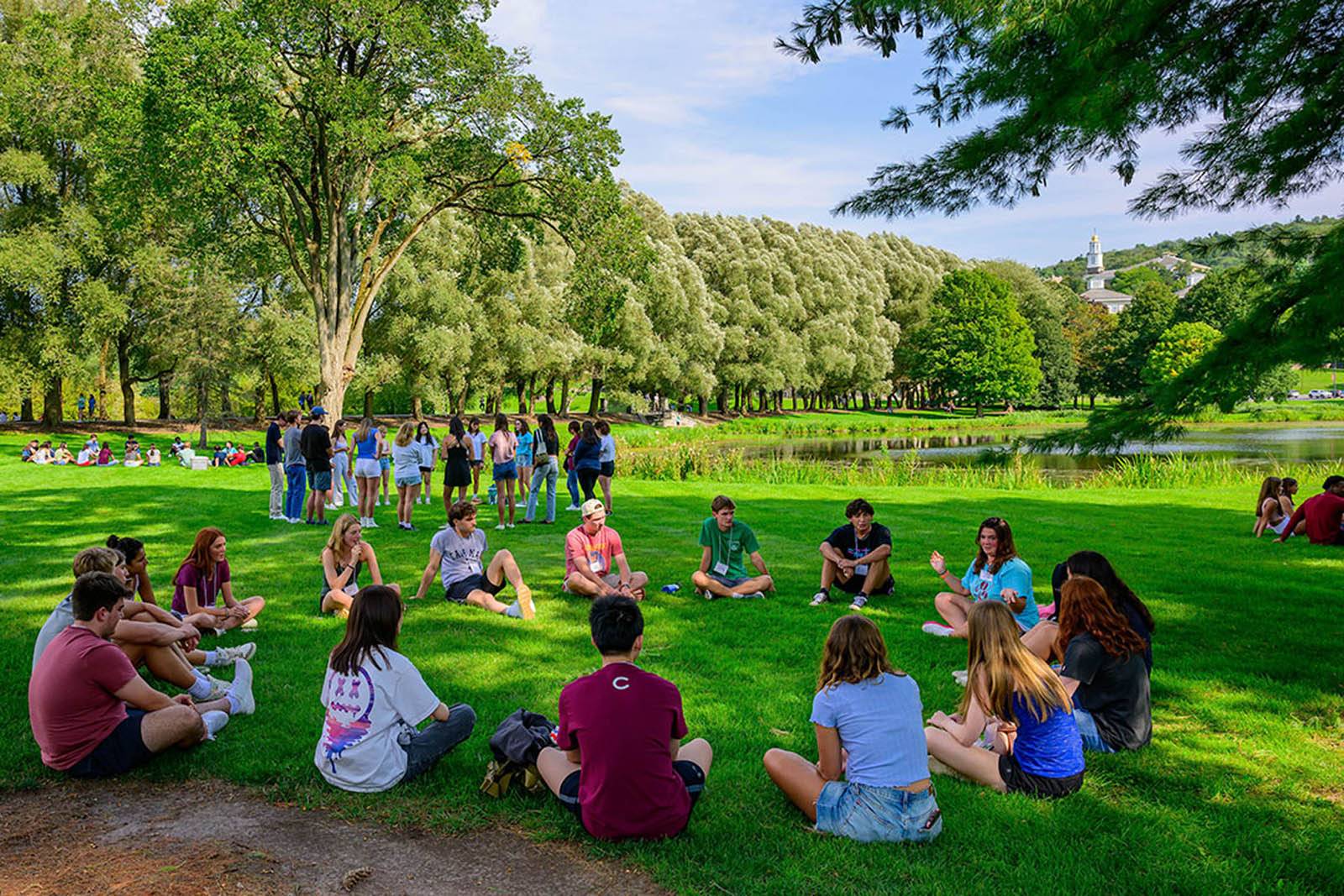 Students sit on the lawn during Orientation