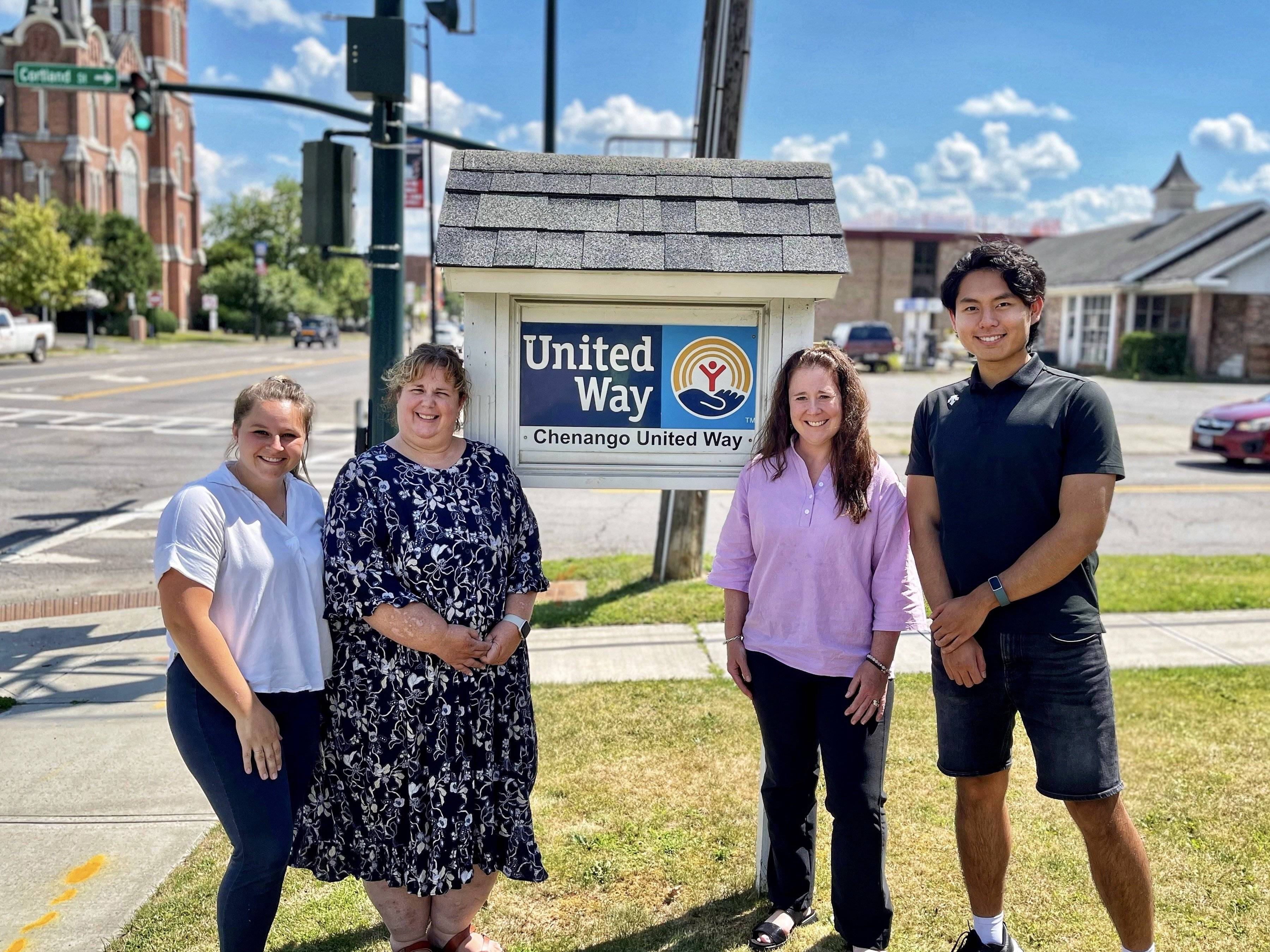 David Xiu stands with United Way staff in front of the United Way sign
