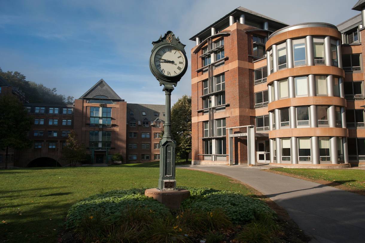 Clock with sidewalk to the right, leading to residential buildings on Colgate's campus