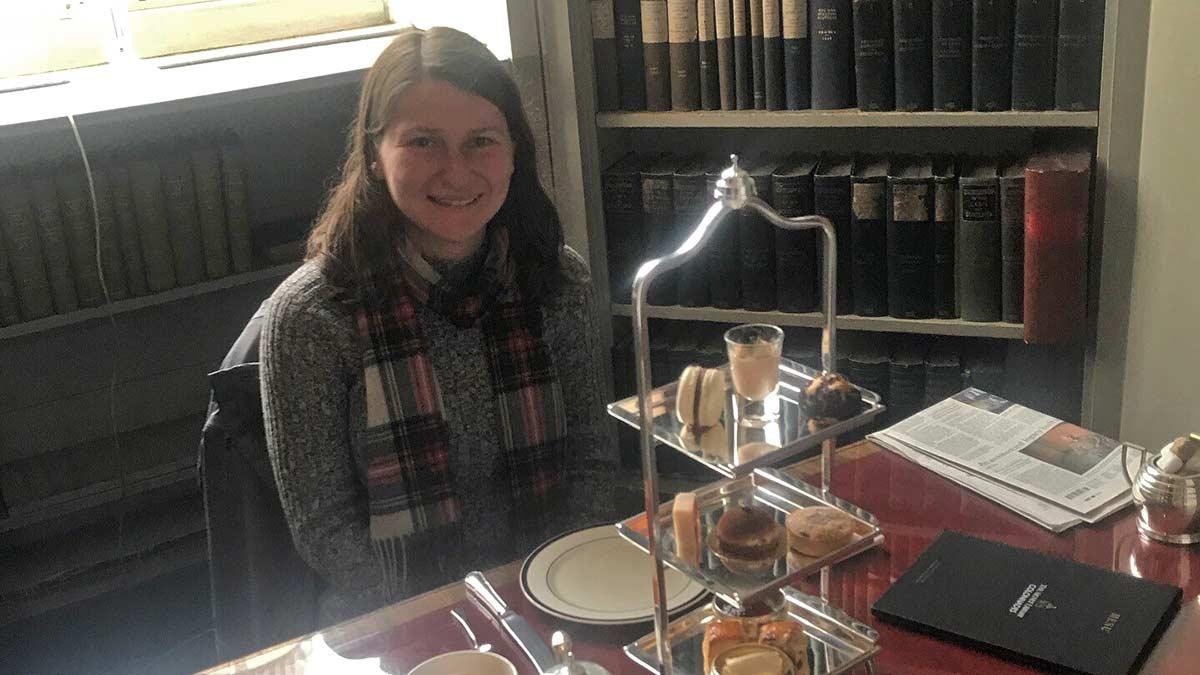 Denise Larson enjoying tea in a book nook of the Signet Library